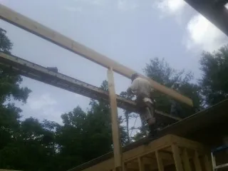Carpenter setting a ridge beam over a new addition frame — Ice Dam Removal by Roofing Brothers in Mountain Rest