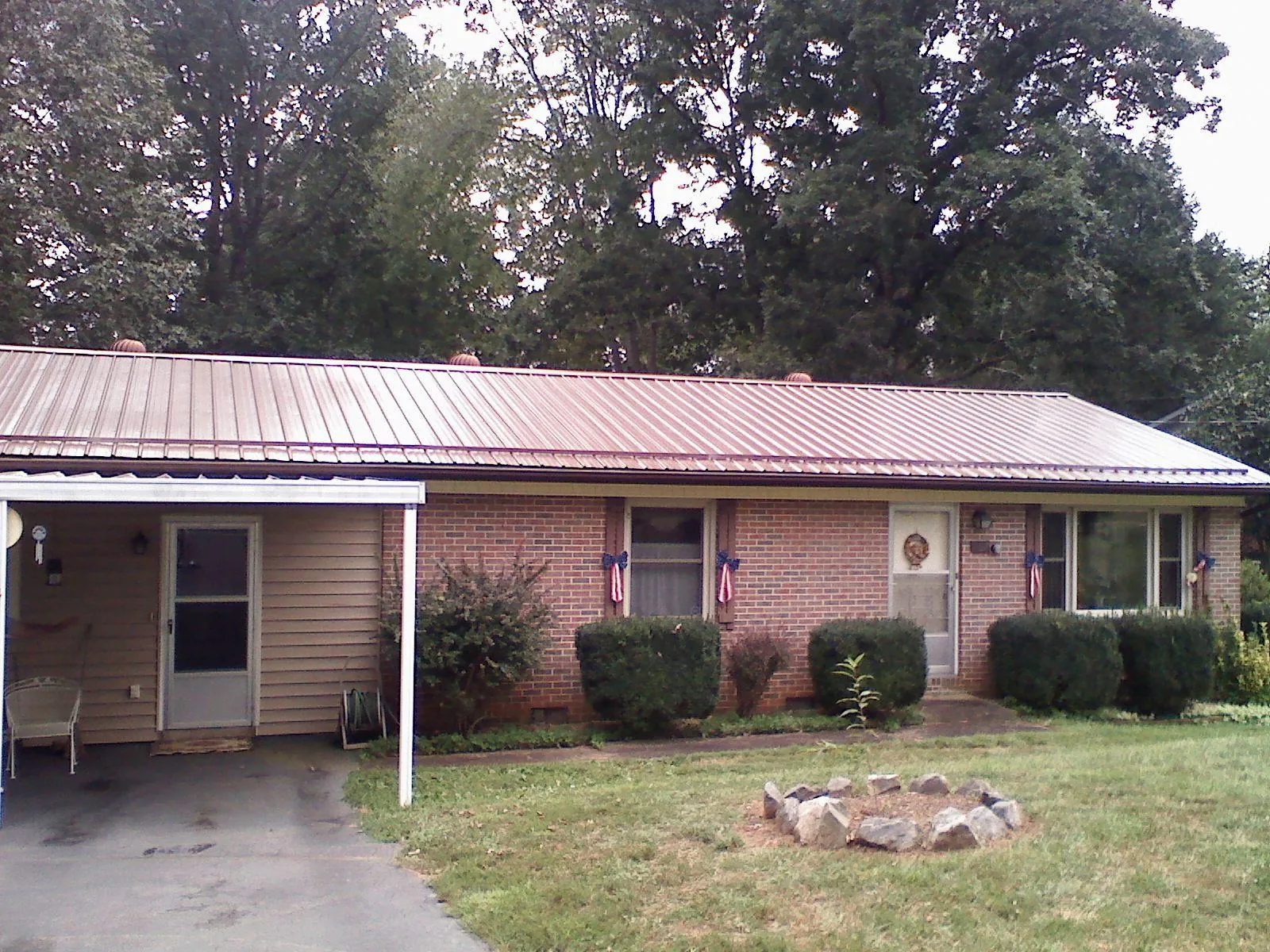 Bronze metal roof and carport on a brick ranch home — Roof Repair work by our crew in Mountain Rest